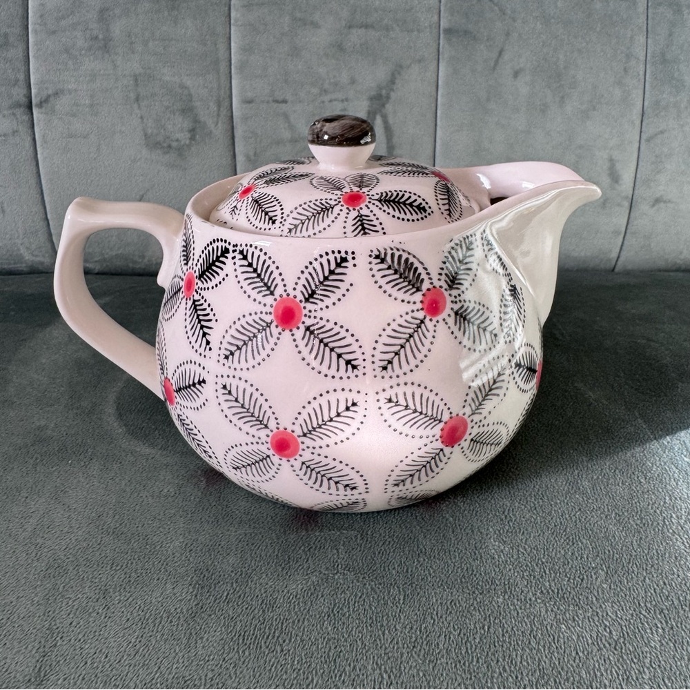Small porcelain tea pot with floral black and red/orange design